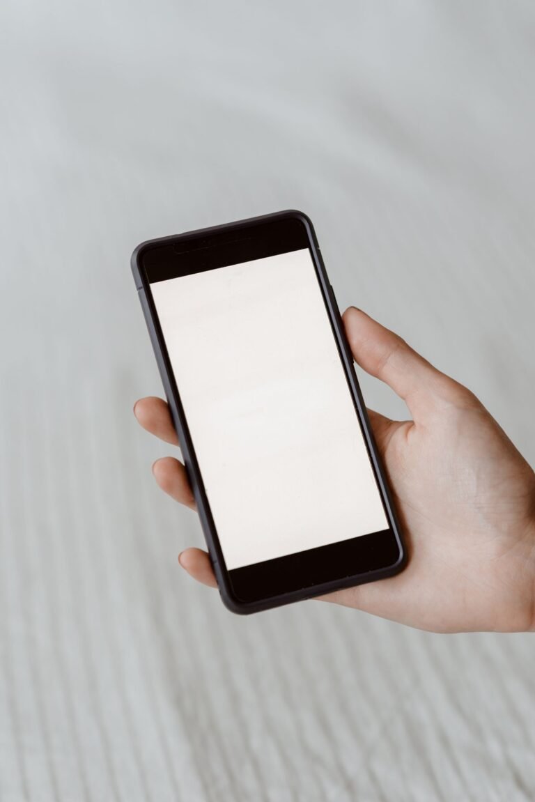 Hand holding a smartphone showing the Xero mobile app for managing finances on the go