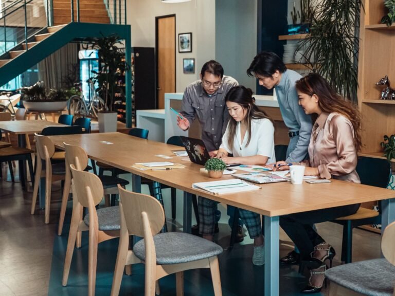 Team collaborating around a table discussing Xero payroll